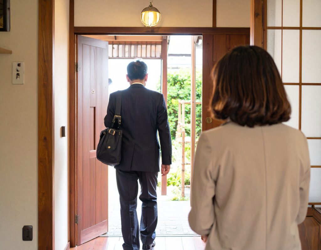 家を出ていく夫と見送る妻